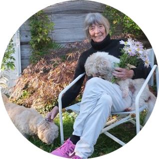 Barbara Norfleet '47, H'14 holding flowers and a dog.